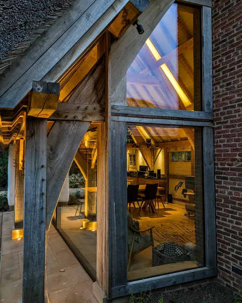 Backlit and uplit beams in a double height thatched pool house
