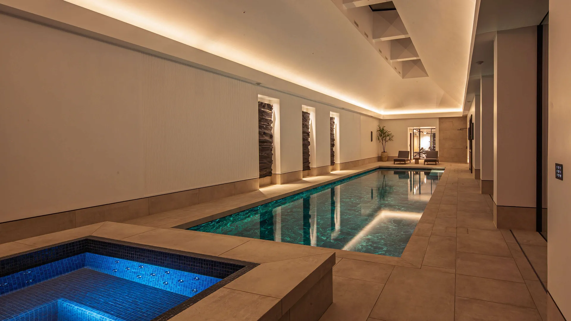 Coffer lighting with lit artwork in a double-height swimming pool