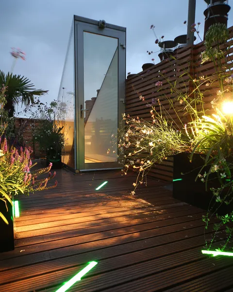 Rooftop garden with colour-changing LED linear lighting set into the decking