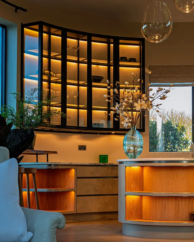 Curved kitchen cabinetry with linear LED lighting